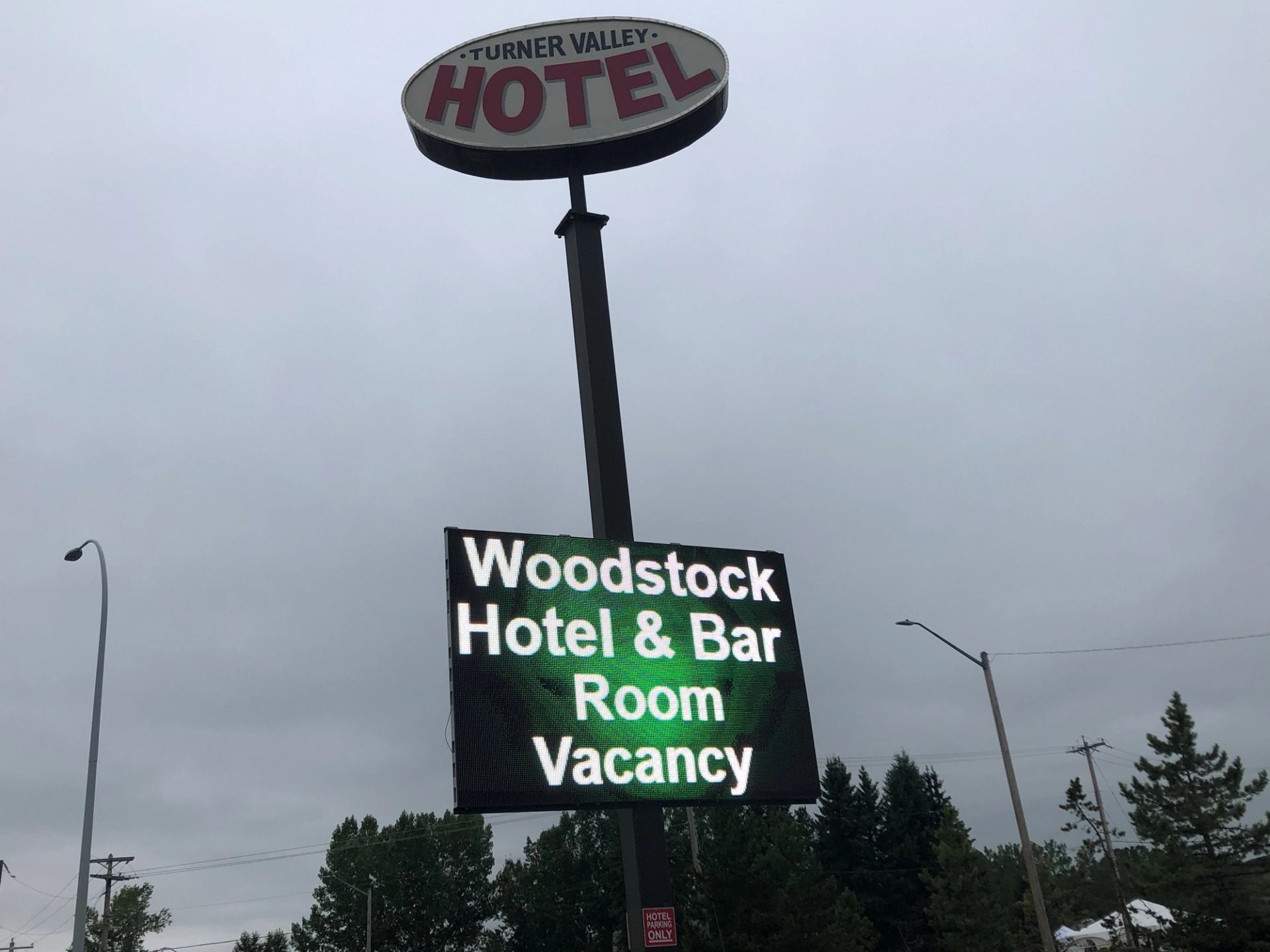 Outdoor sign showing Woodstock Hotel & Bar with room vacancy message