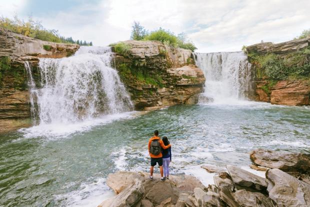 Couple standing together and enjoying the views of Lundbreck Falls.