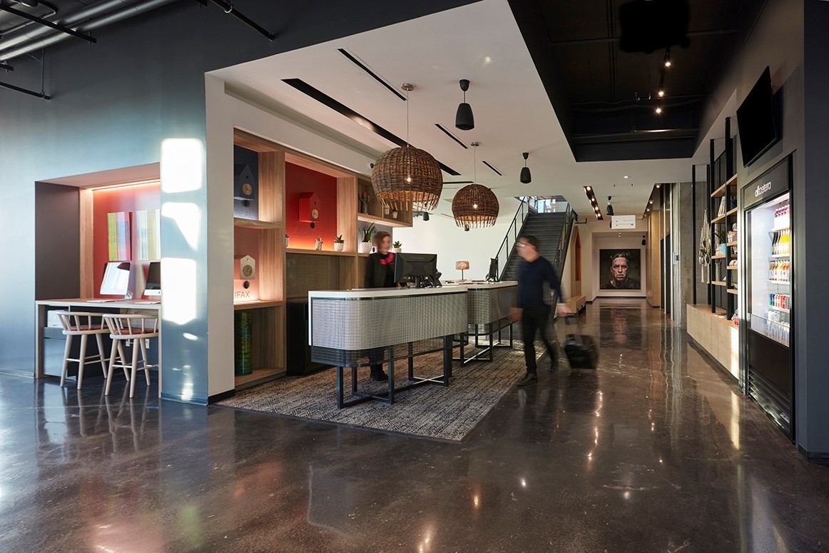 Stylish hotel lobby with modern décor, reception desk, and warm lighting.