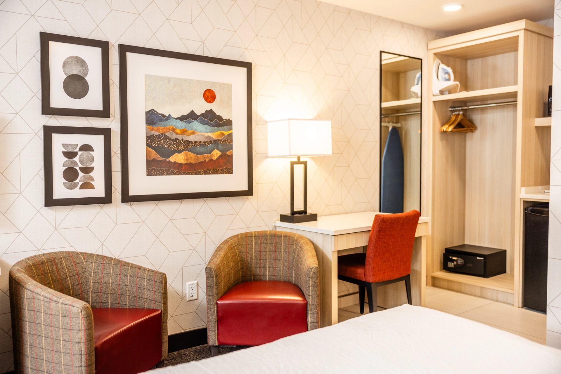 Hotel room with chairs, desk, and open closet at Mountaineer Lodge.