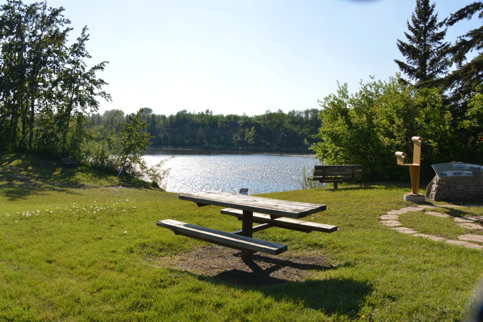 A picnic table sits with a view of the Red Deer River.