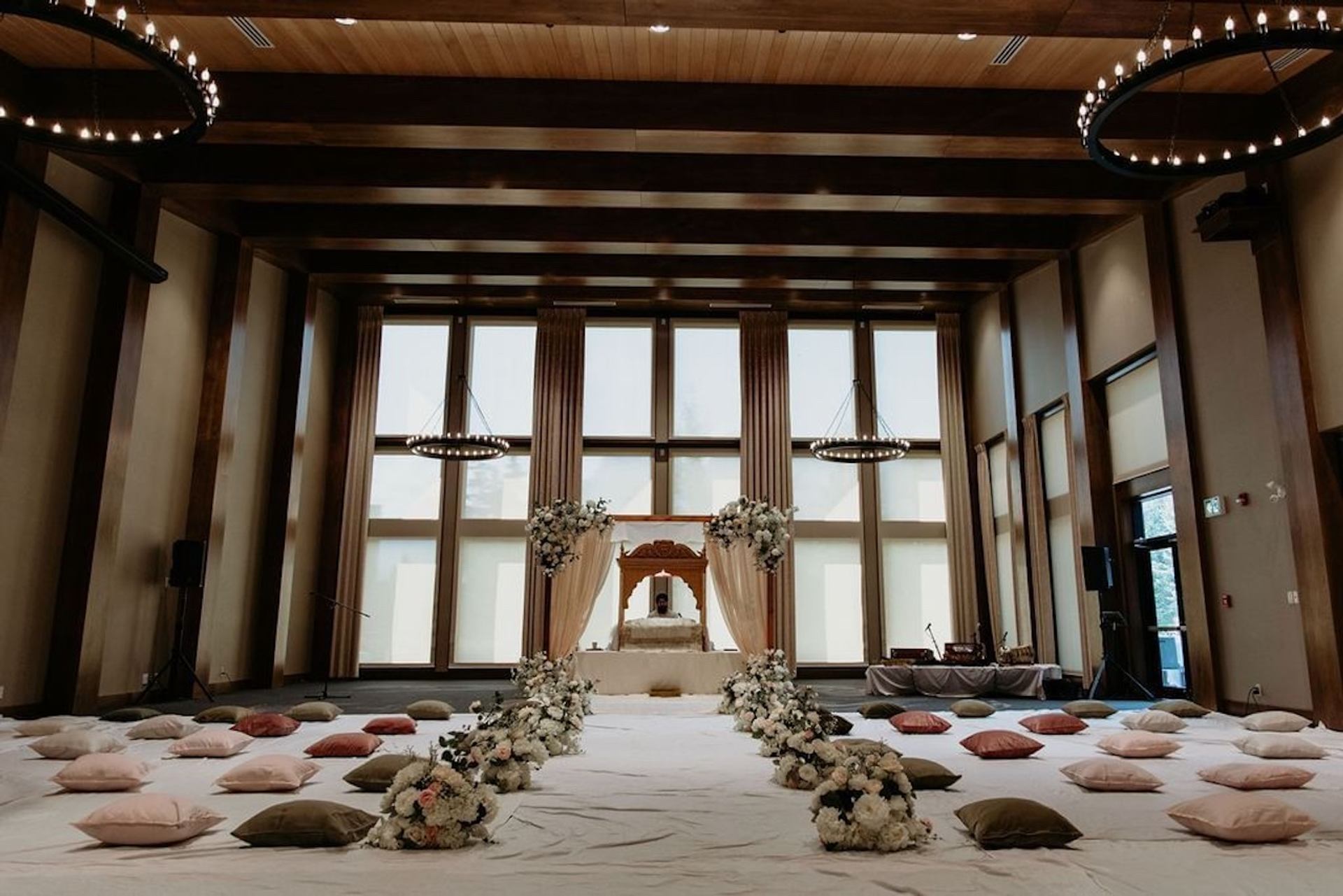 Indoor ceremony room with floral aisle, soft pillows, and draped altar