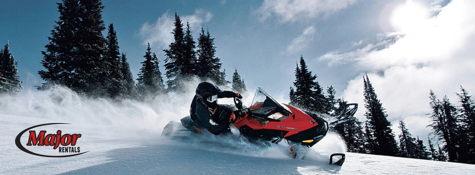 Snowmobile racing through snowy woods with Major Rentals branding.