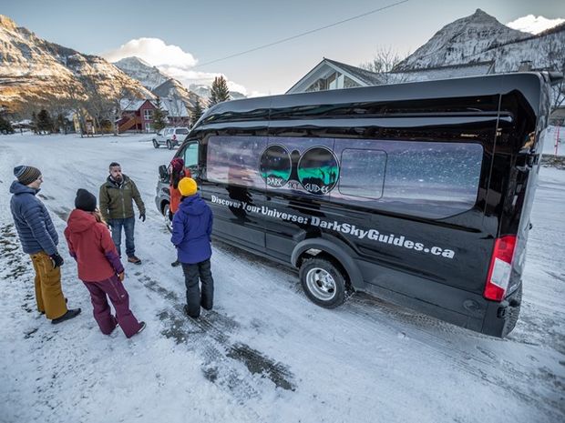 Guide and visitors waiting to get on a Dark Sky tour bus.