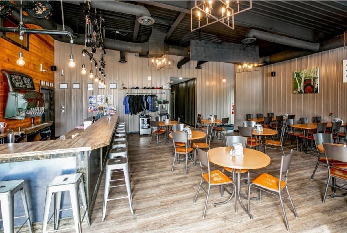 Piston Broke Brewing welcomes guests into a spacious taproom with tables and a bar.