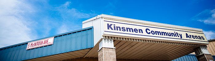 Exterior view of Kinsmen Community Arenas building with signage and covered entrance.
