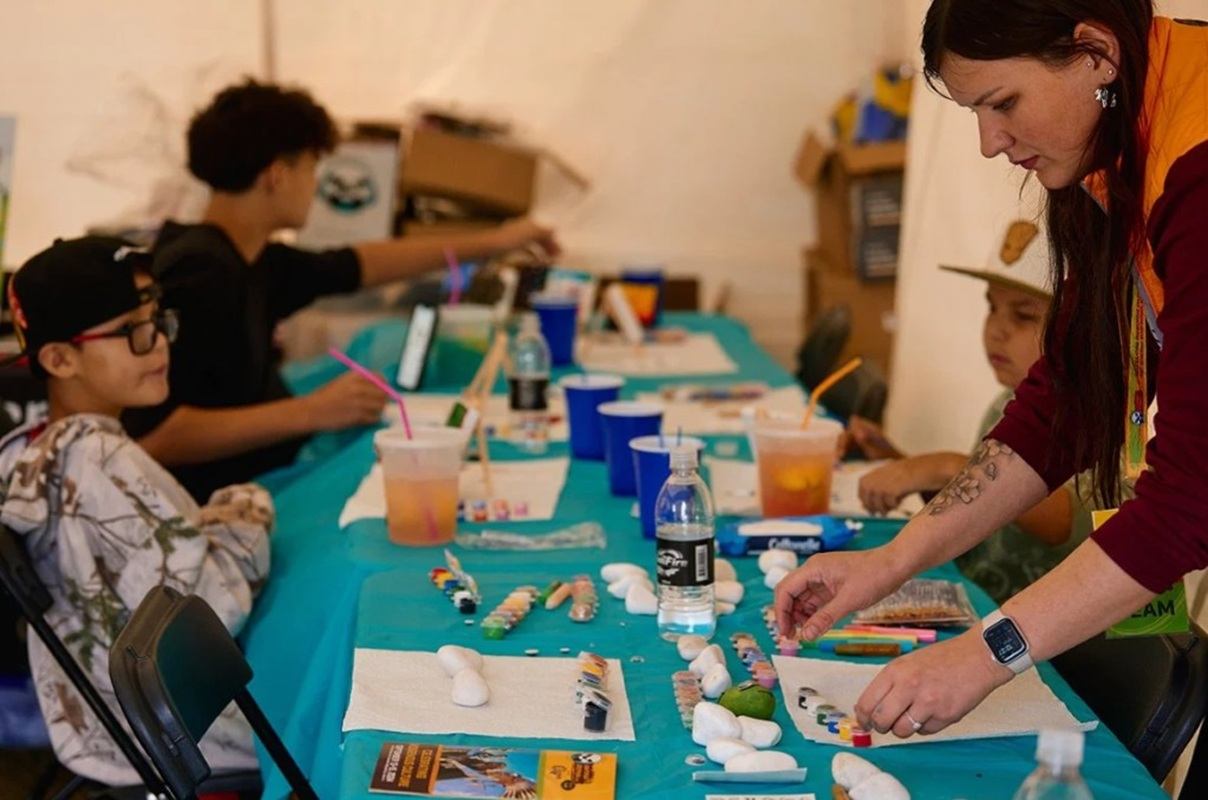 Children paint and craft at a festival activity table