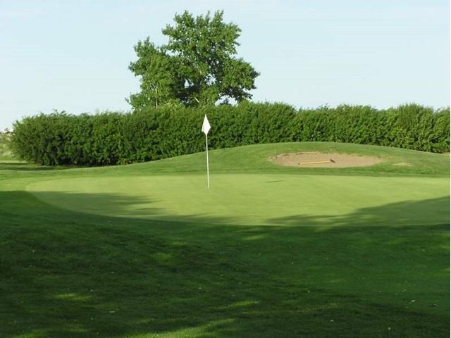 Golf green with flag and sand bunker at Hanna Golf and Country Club.