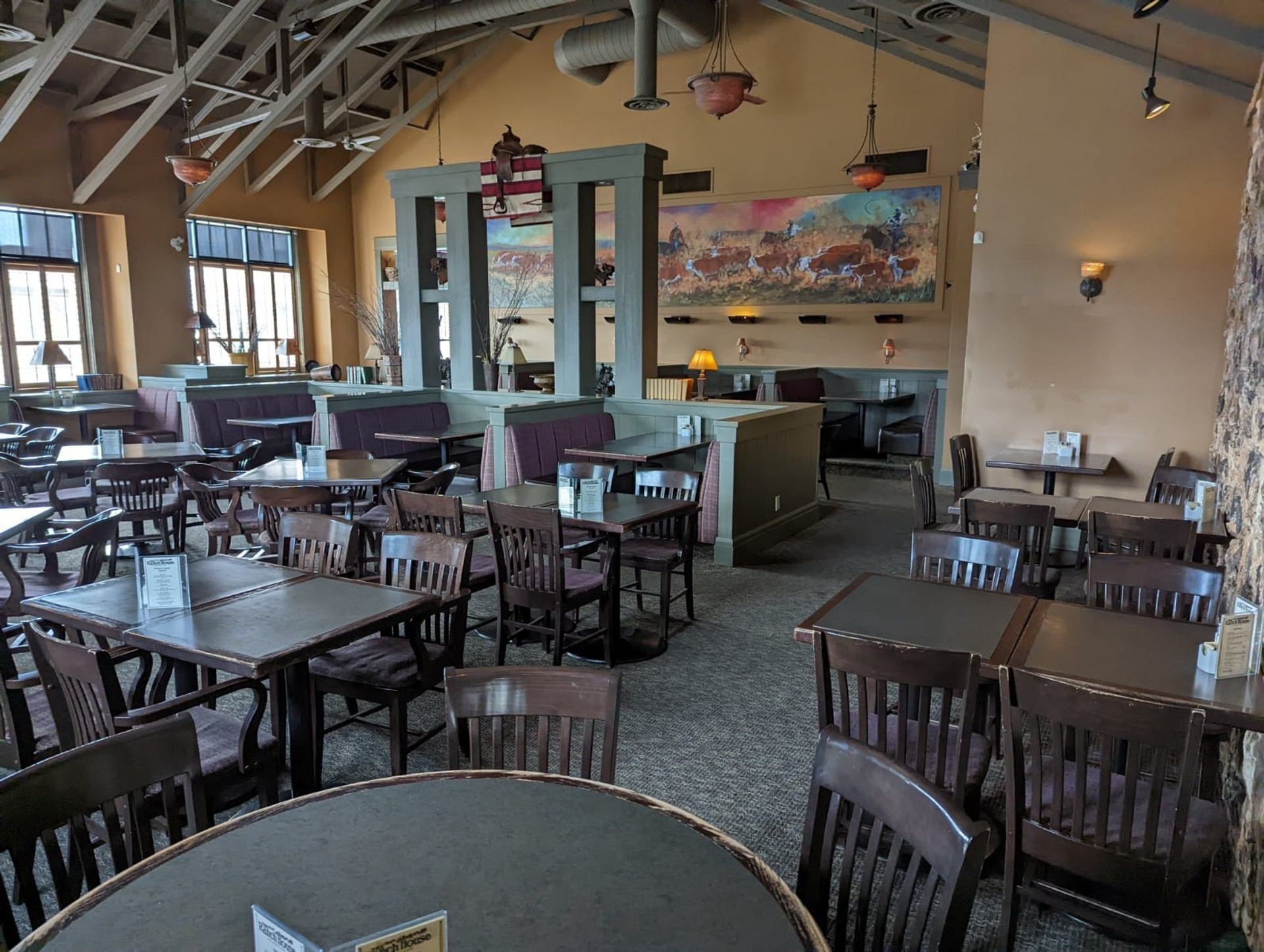 Large dining area with wooden tables, chairs, and rustic décor