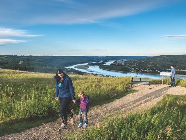 A woman and child holding hands walking up the trail