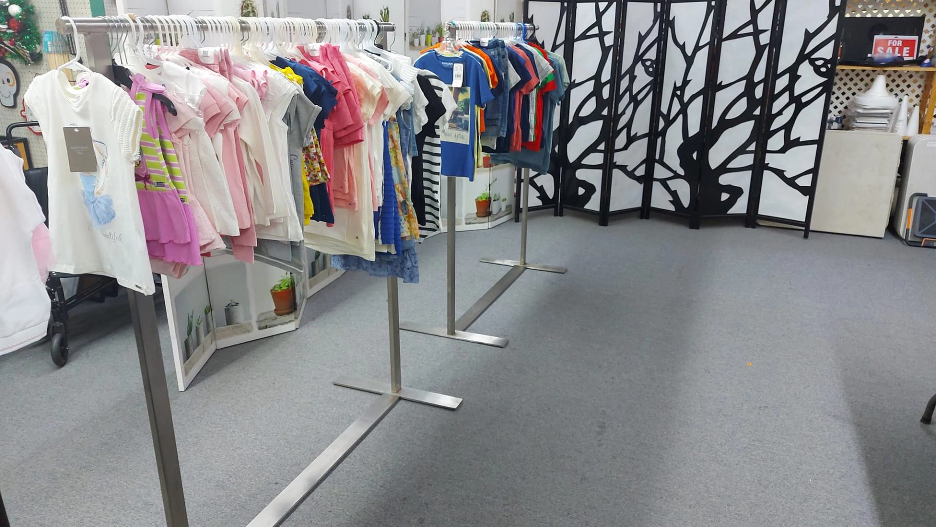 Clothing racks filled with colorful kids apparel inside Runwayz Boutique.