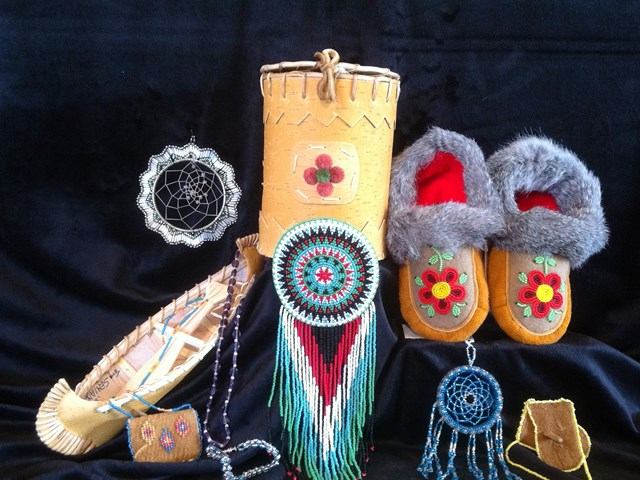 Native American crafts: moccasins, dreamcatchers, and beaded items on black background.