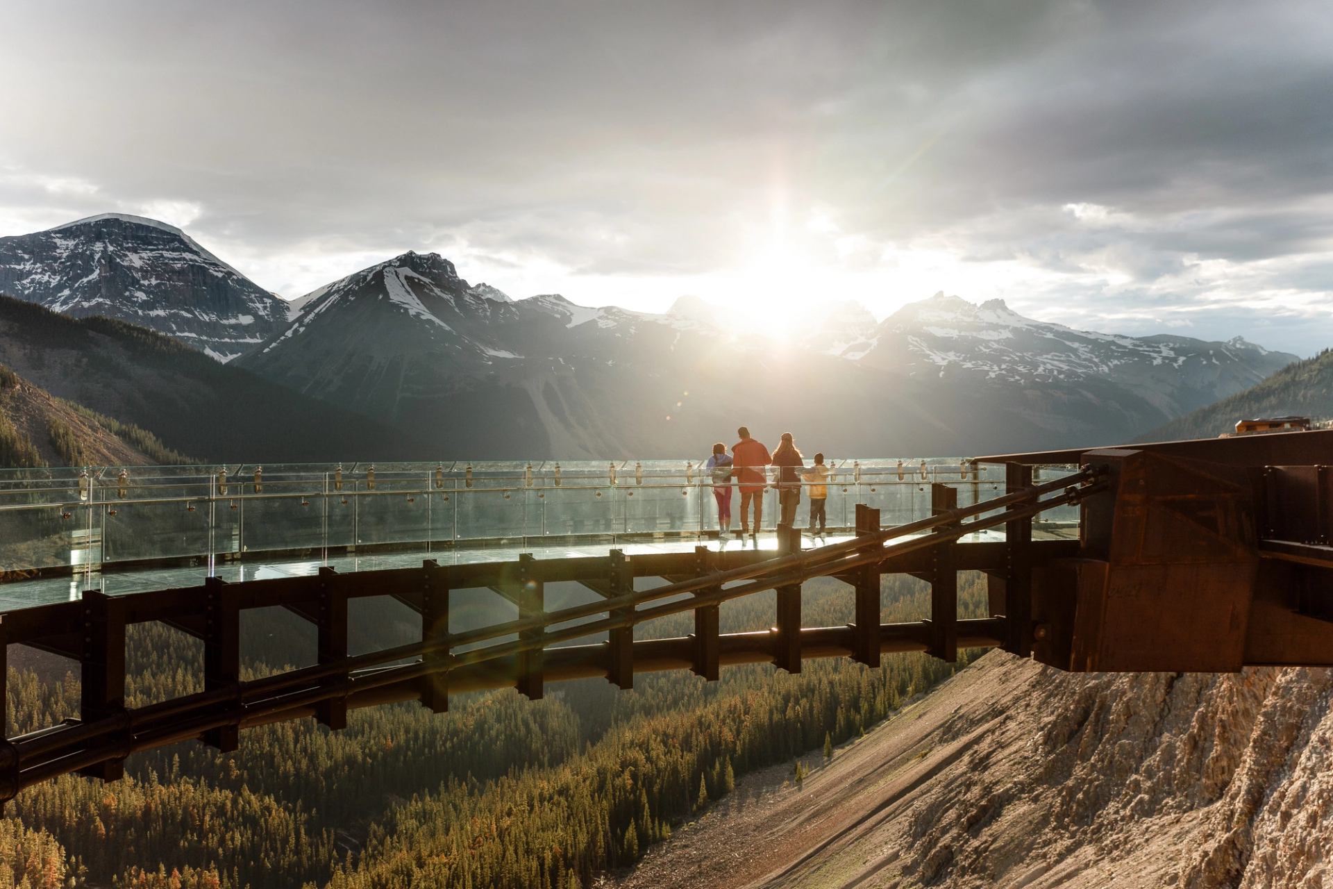 Family standing on the Columbia Icefield Skywalk watching the sunset in Jasper National Park.