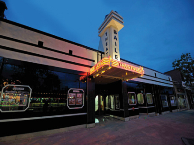 Bailey Theatre marquee and tower beside a black train car at the entrance.