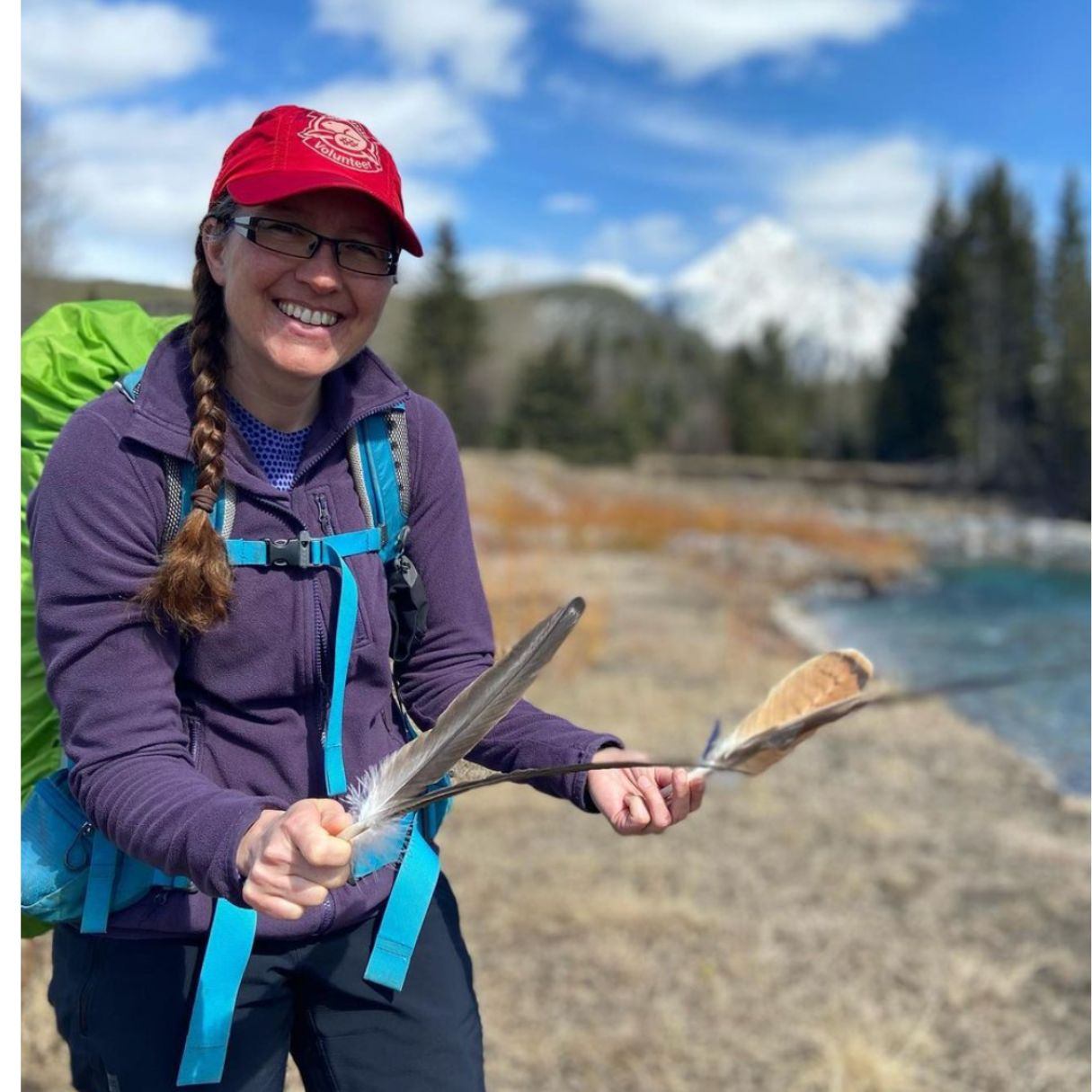 A lady holding a feather backpacking