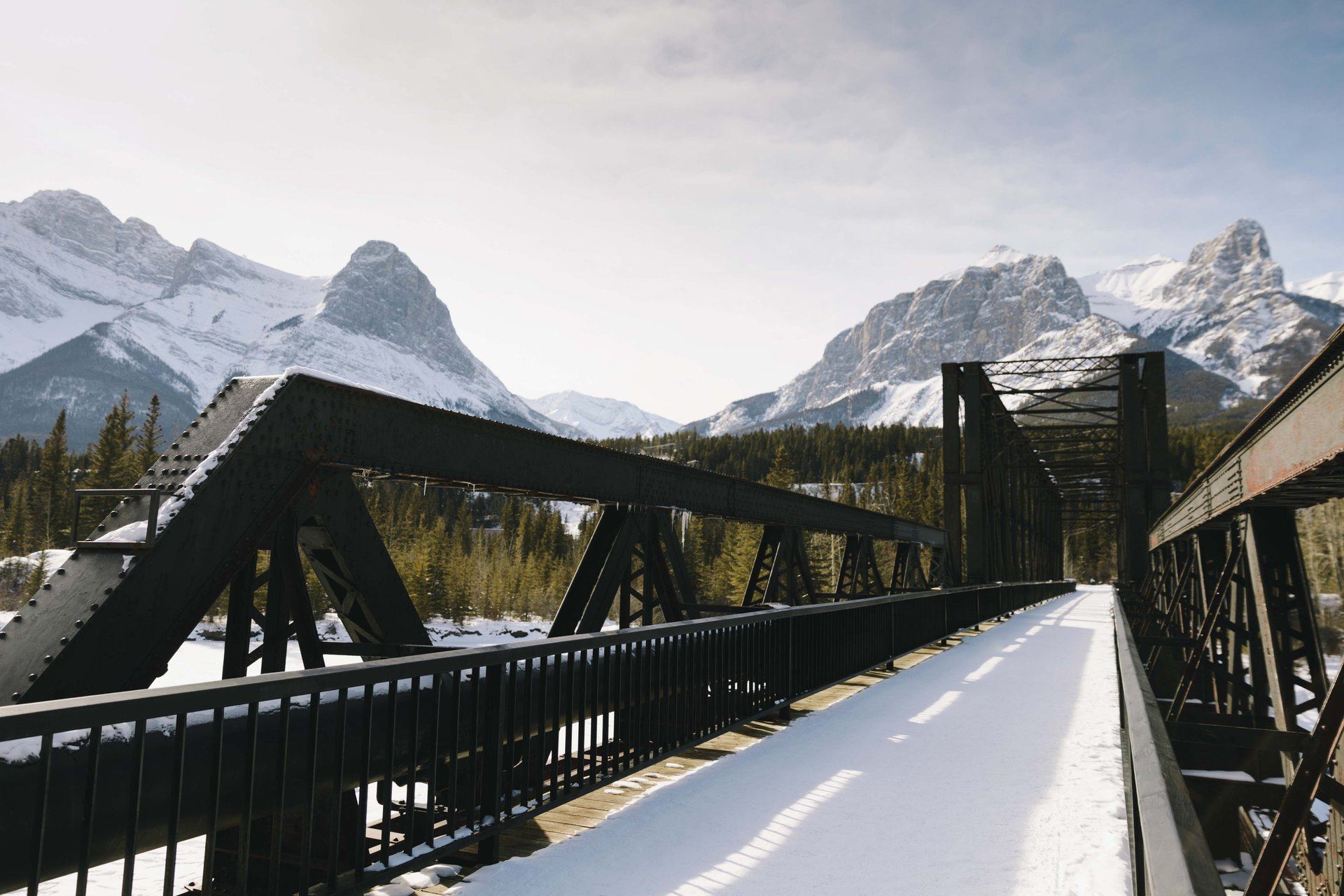 Canmore Engine Bridge in the winter with mountains in the background.