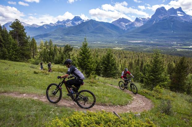 People mountain biking on trail in Canmore Nordic Centre Provincial Park.