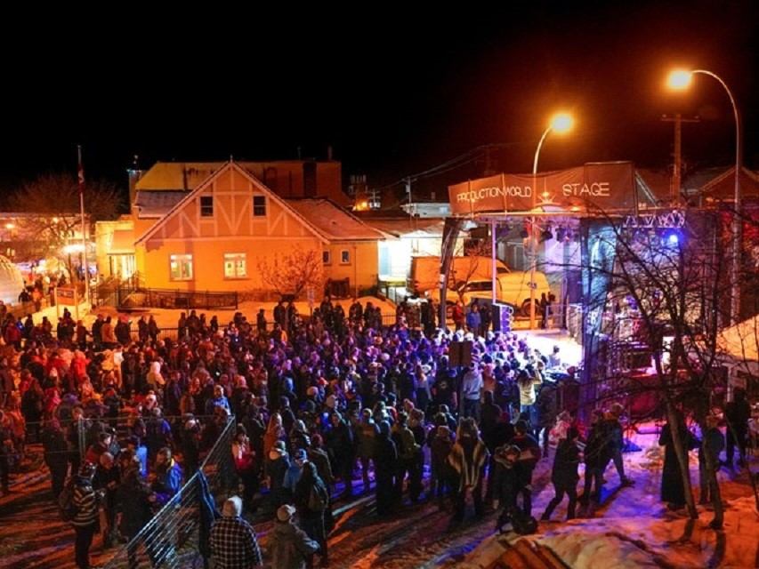 Crowd gathered at an outdoor stage with colorful lights during Jasper in January.