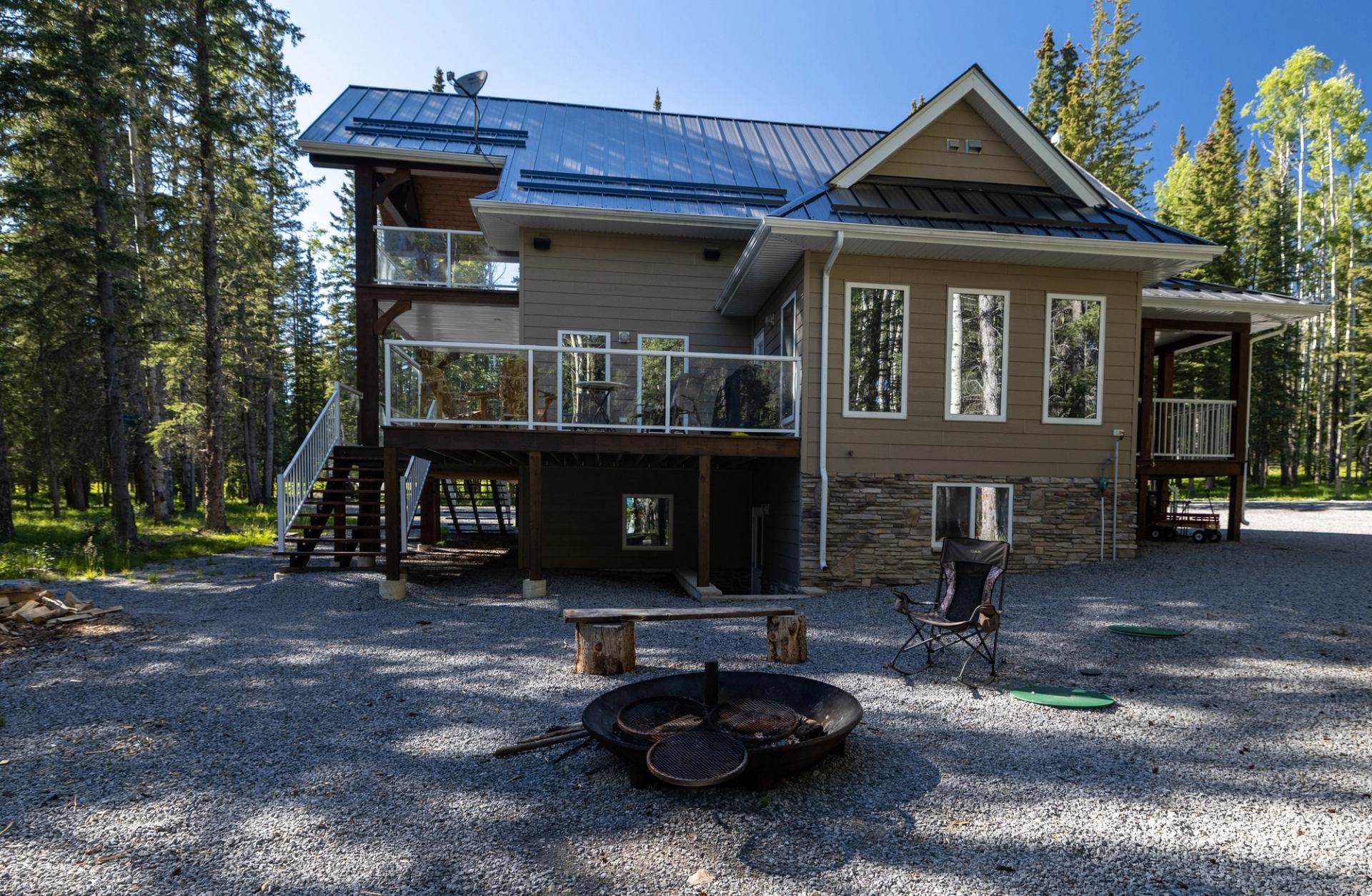 Modern two-story house with balcony and fire pit.