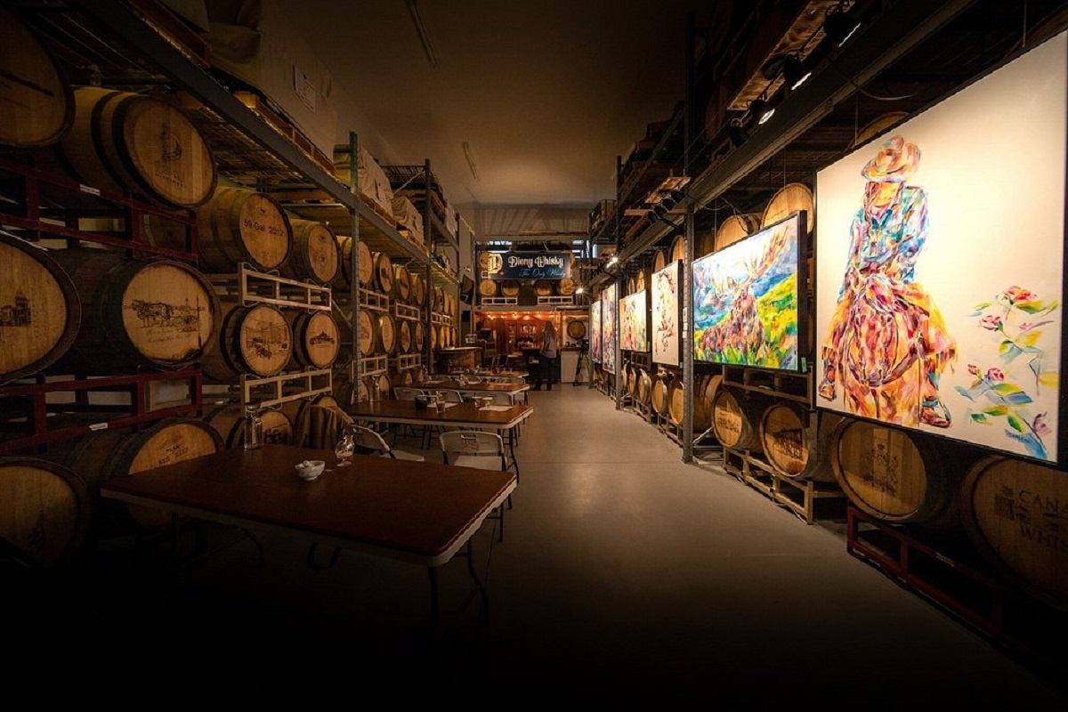 The tasting room with art hung around the wooden barrels.