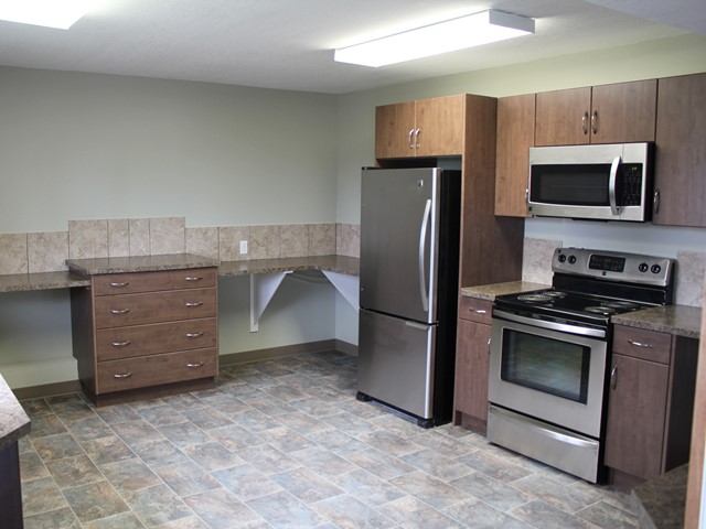 Kitchen with stainless refrigerator, stove, microwave, and tiled floor in Centennial Reunion Square .