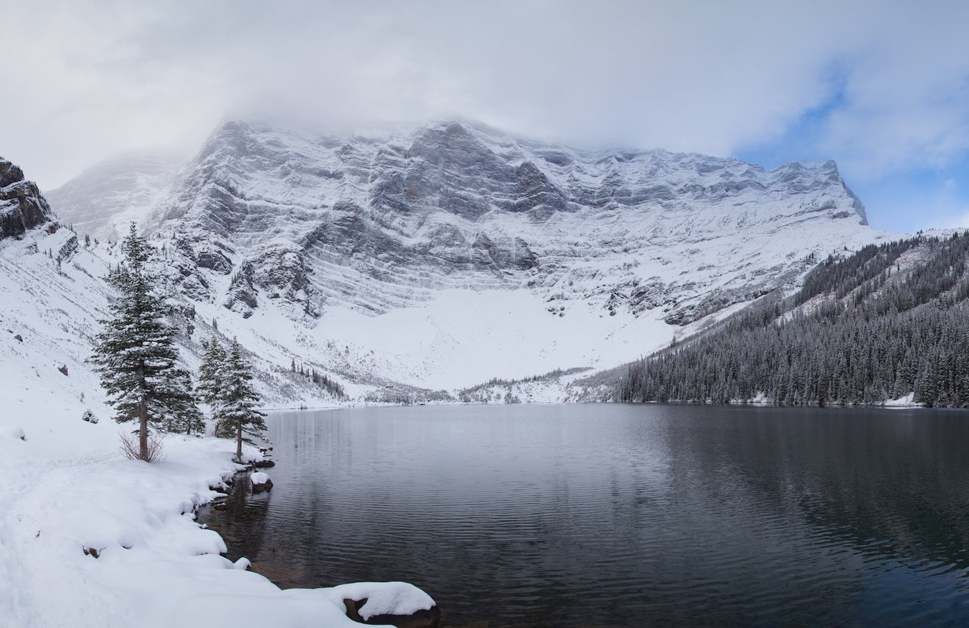 Snow-covered mountains rising above a calm lake along Rawson Lake.