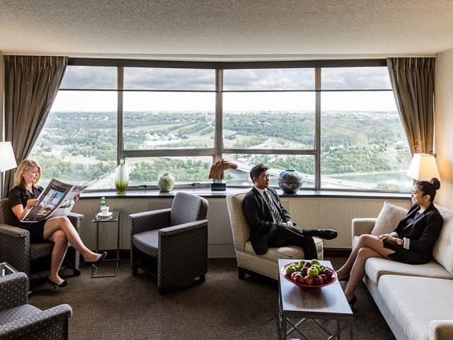 Lounge with seating, large windows, and guests in conversation.