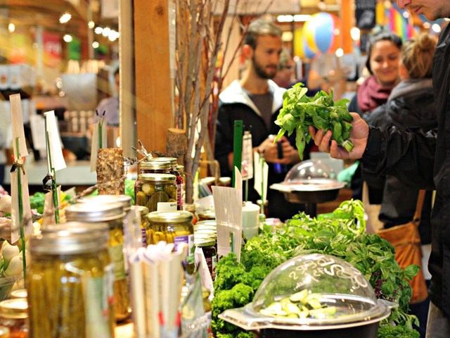 Shoppers browsing fresh greens and pickled goods at Calgary Farmers' Market South