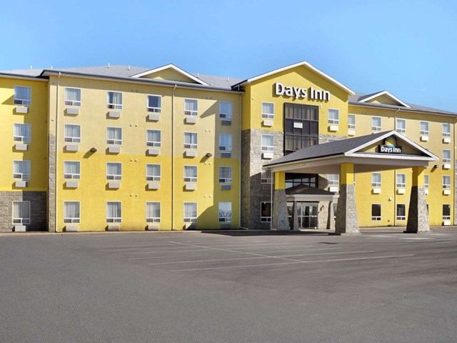 Exterior view of Days Inn hotel with bright yellow facade.