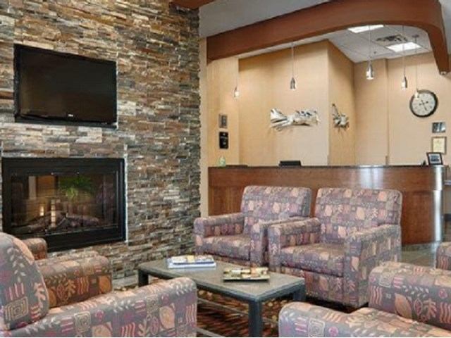 Cozy lobby with fireplace, armchairs, and reception at Best Western Plus Chateau Inn.