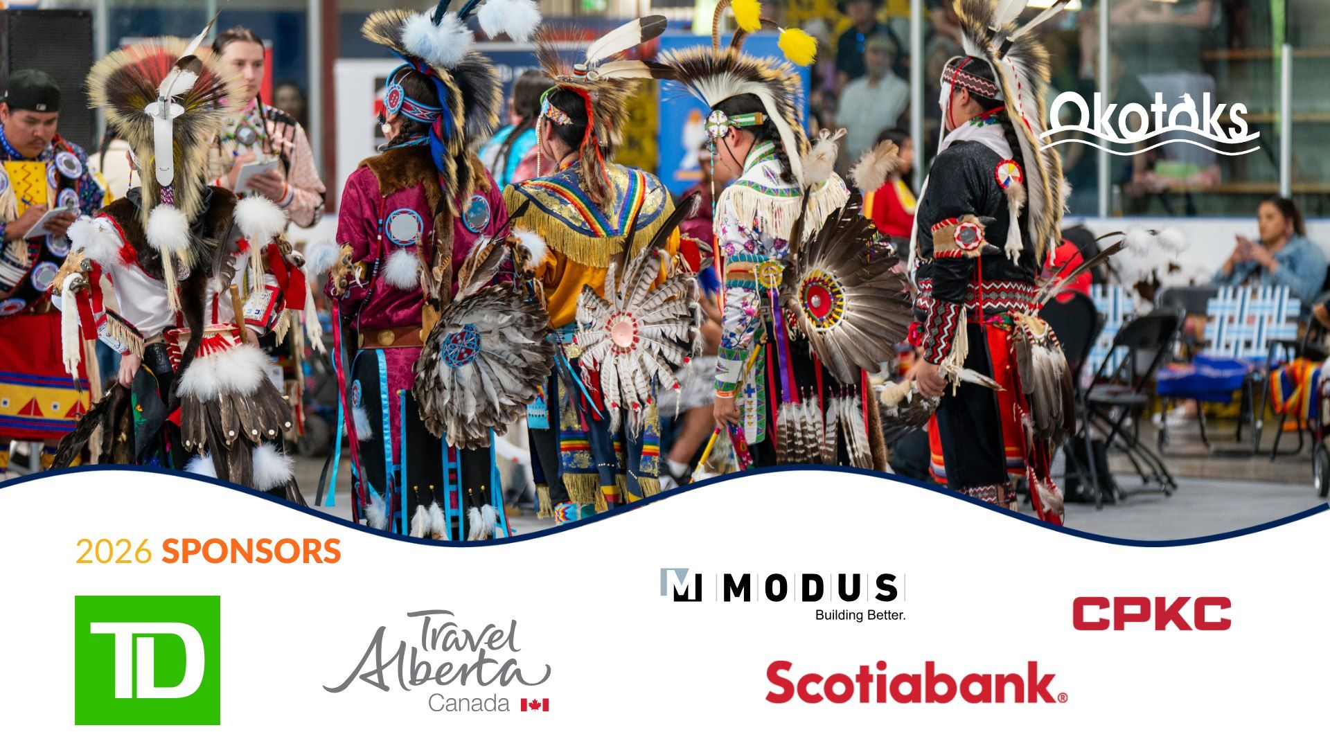 Powwow dancers in colourful regalia with feather bustles, sponsor logos displayed below.