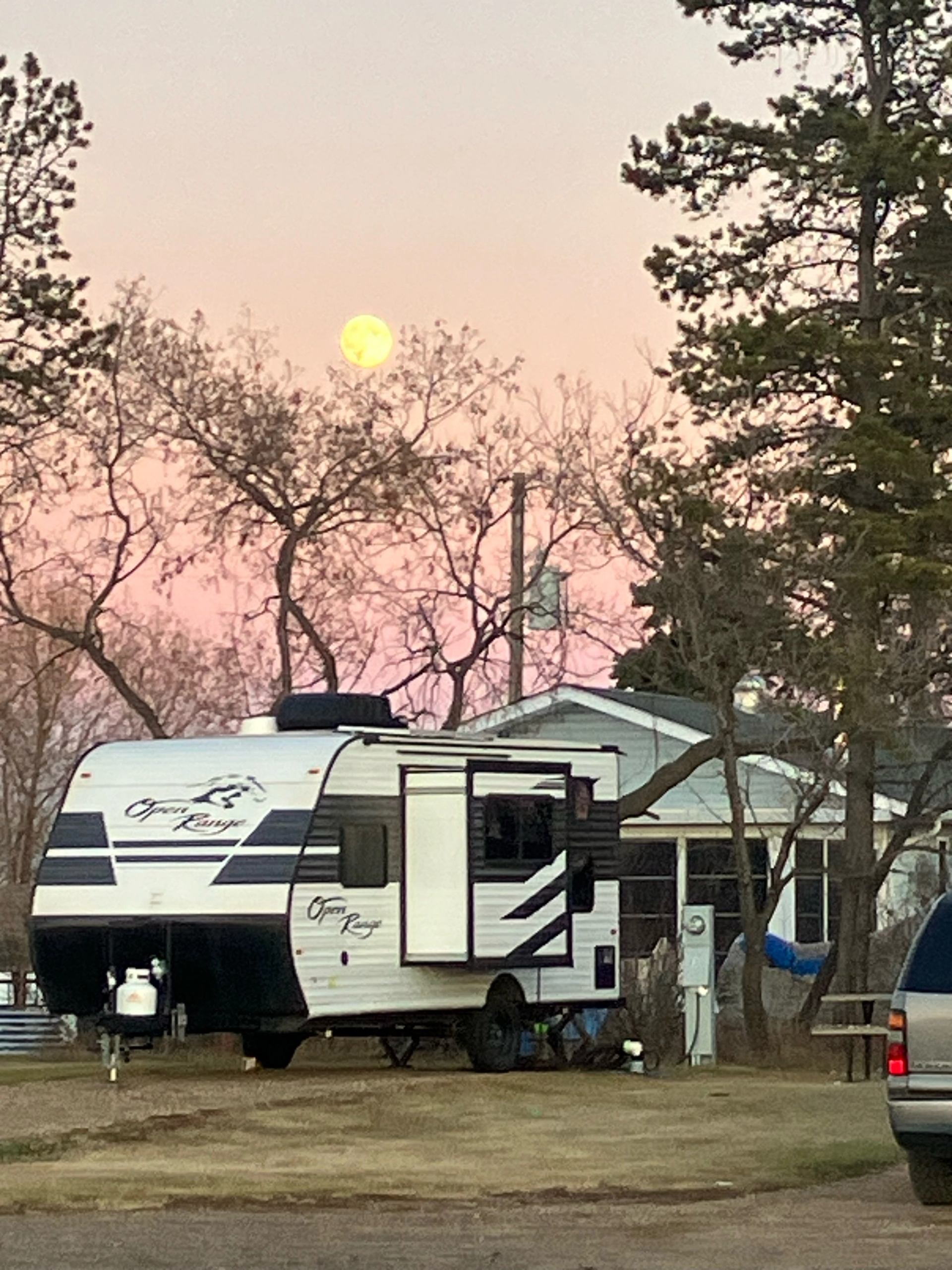 RV parked under a pink sunset sky at Lamont RV Park and Campground.