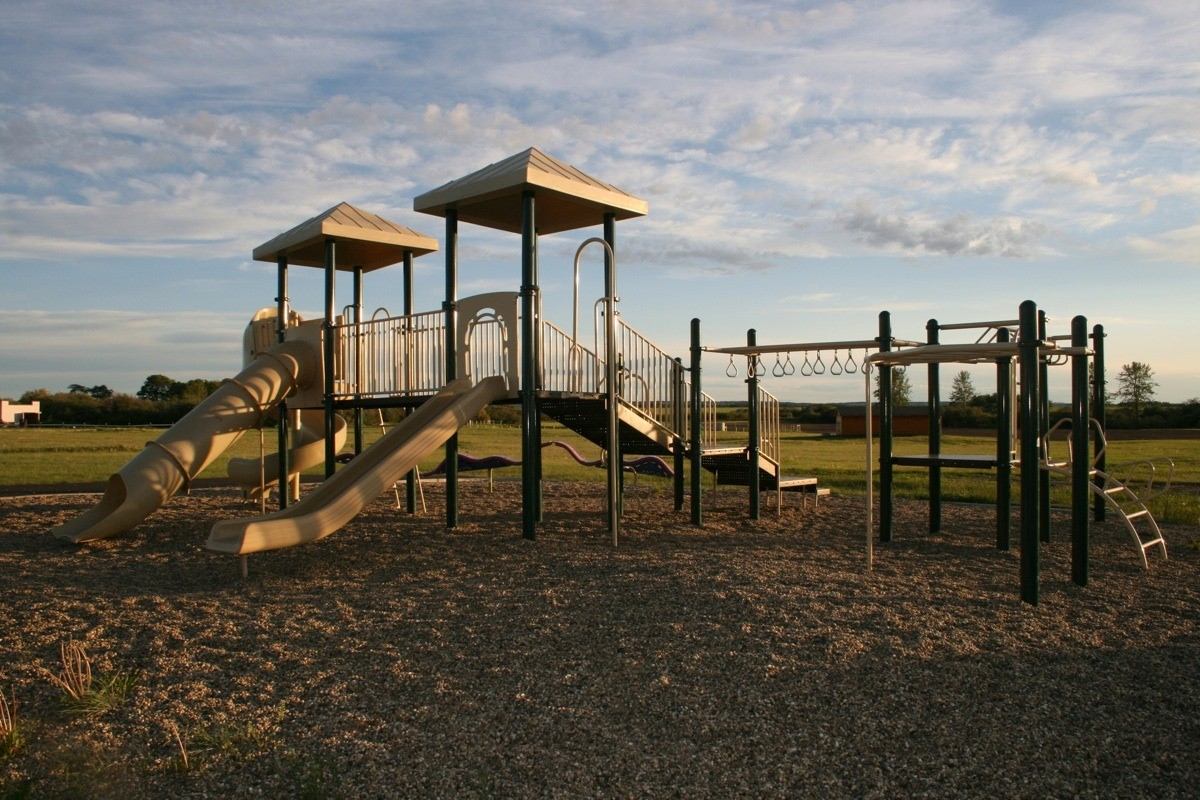 Playground with slides, climbing structures and swings at Happy Trails Campground and Cabins.