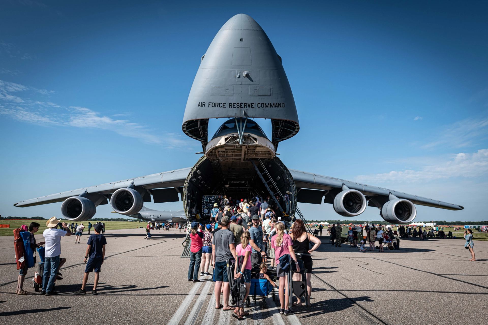 Visitors explore cargo plane with open nose at Cold Lake Air Show.