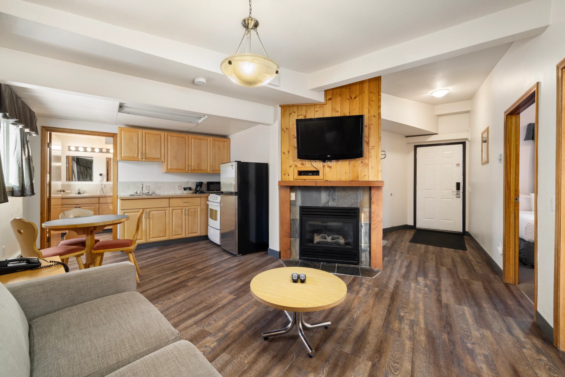 Warm lodge living area with fireplace, couch, and dining table.