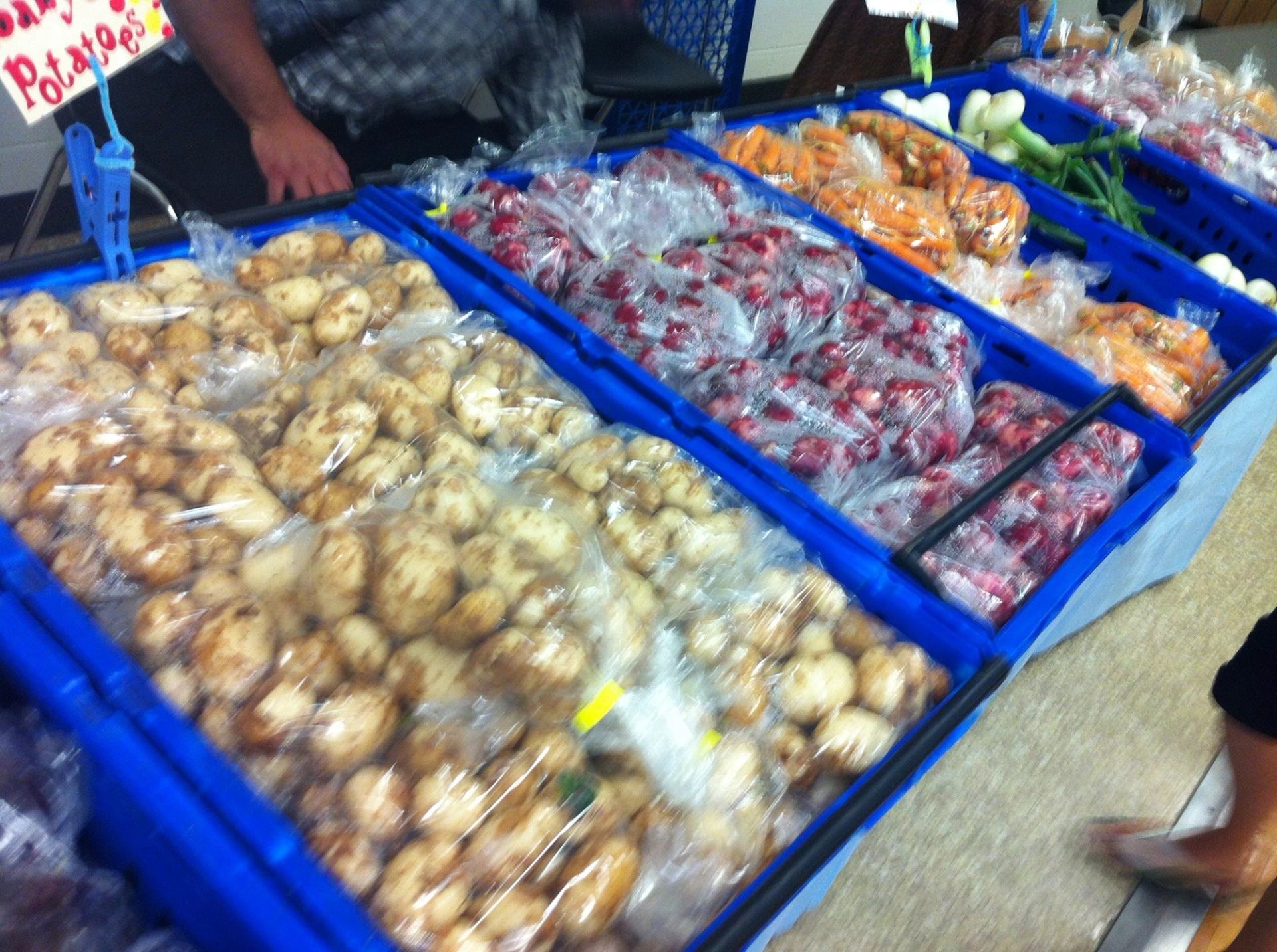 Fresh produce in blue crates at Boyle Farmers' Market stall.