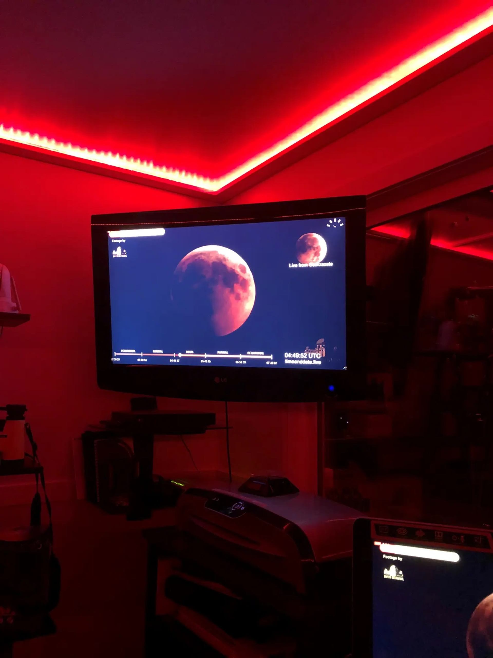 Red-lit room with Mars imagery on screen and space equipment.