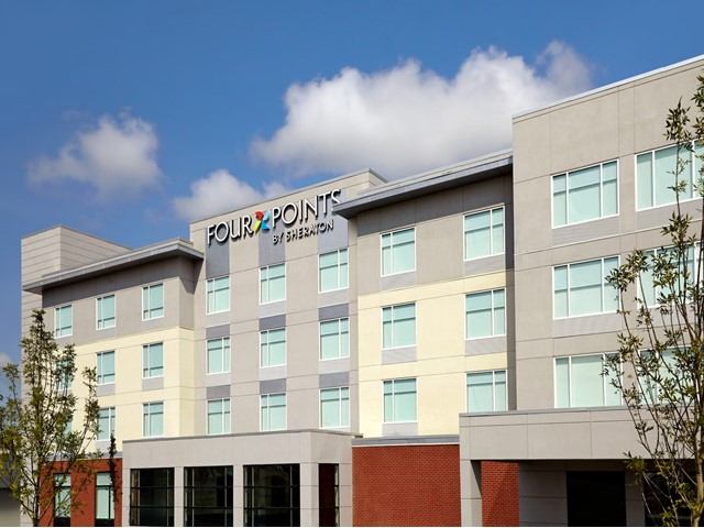 Exterior of Four Points Edmonton Airport hotel with modern design and clear sky.