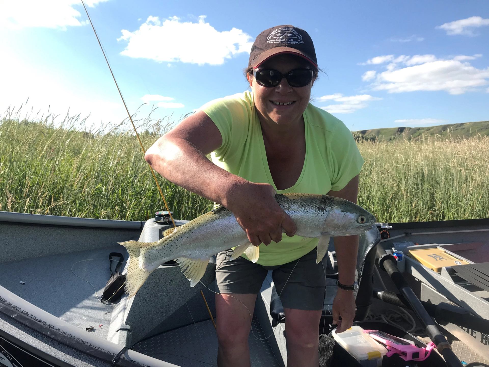 A women in a boat holding her catch.