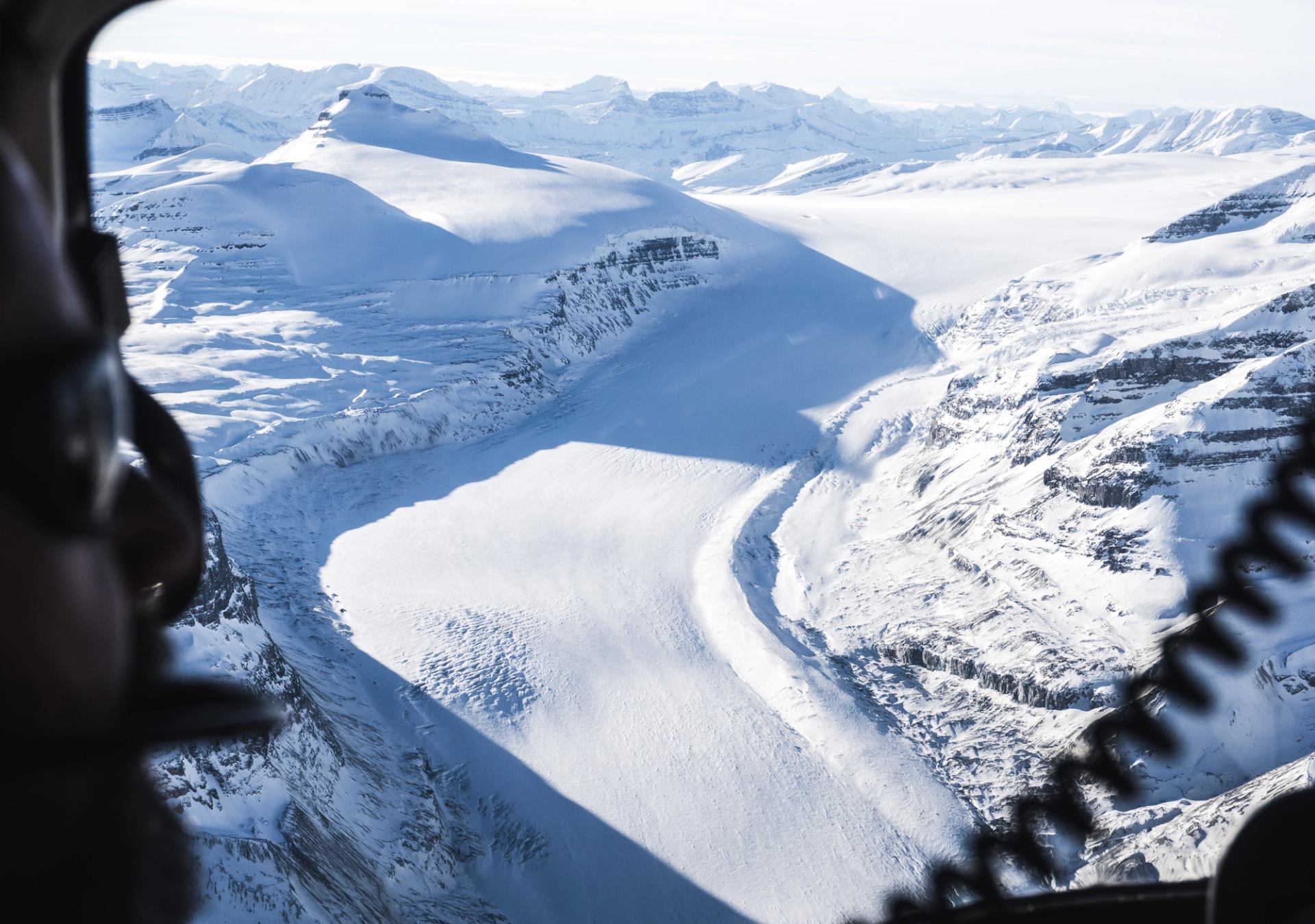 View from inside a helicopter overlooking a vast Columbia Icefield glacier.
