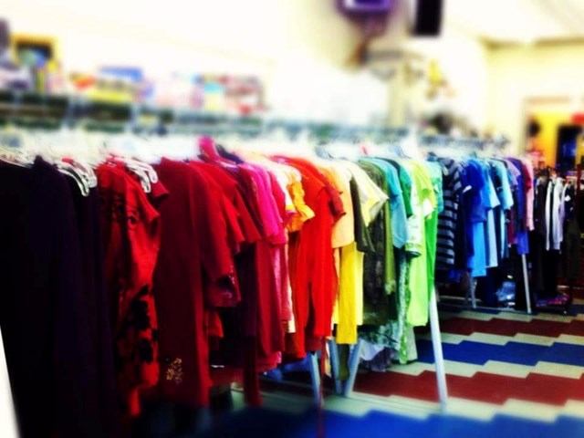 Clothing rack with colourful shirts and T-shirts in a retail store.