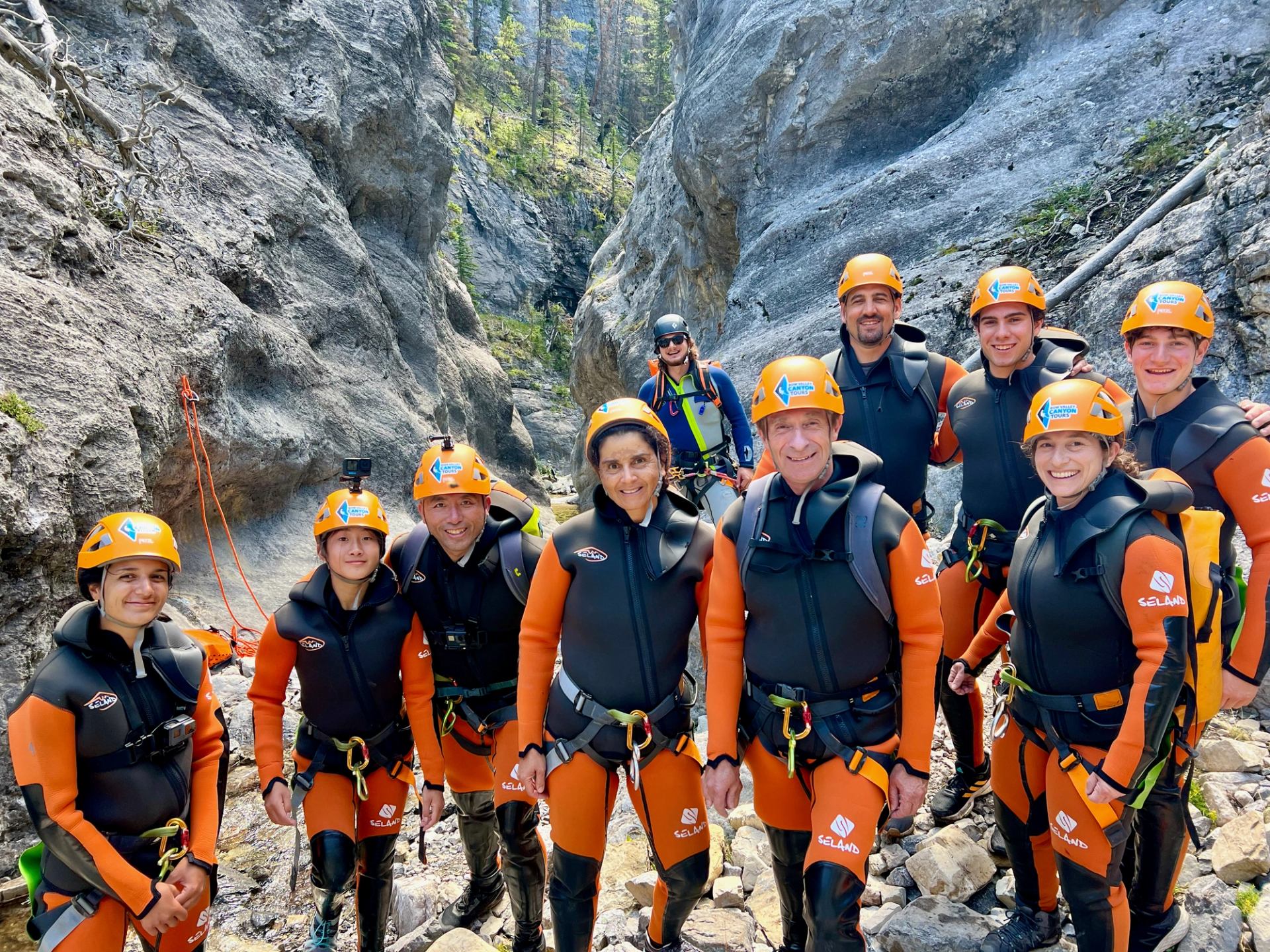 Group of canyoning adventurers posing in a rocky gorge in Bow Valley.