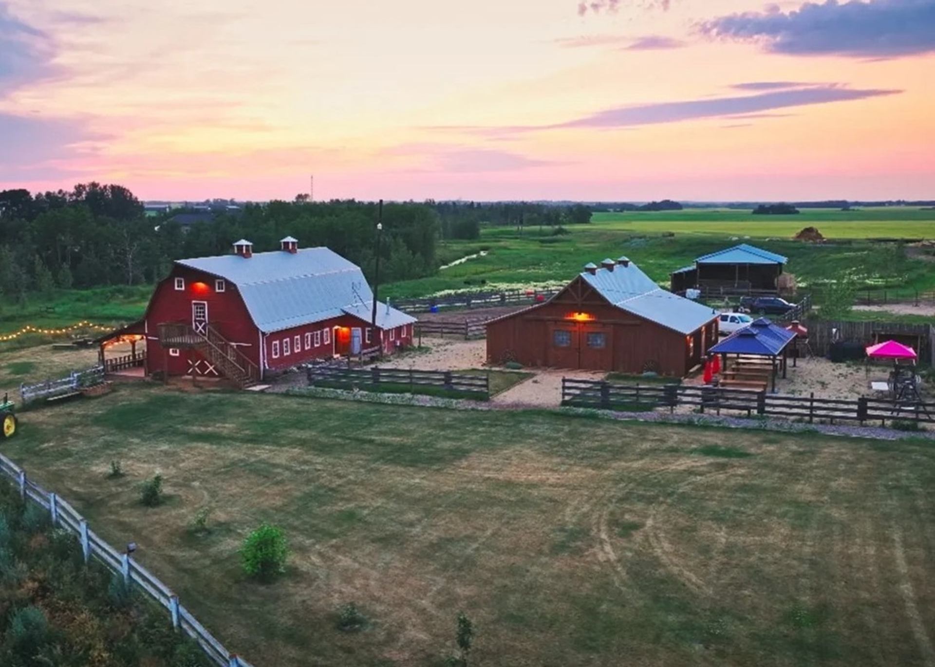 Old Red Barn showcases its scenic farmyard and red barn buildings at sunset.