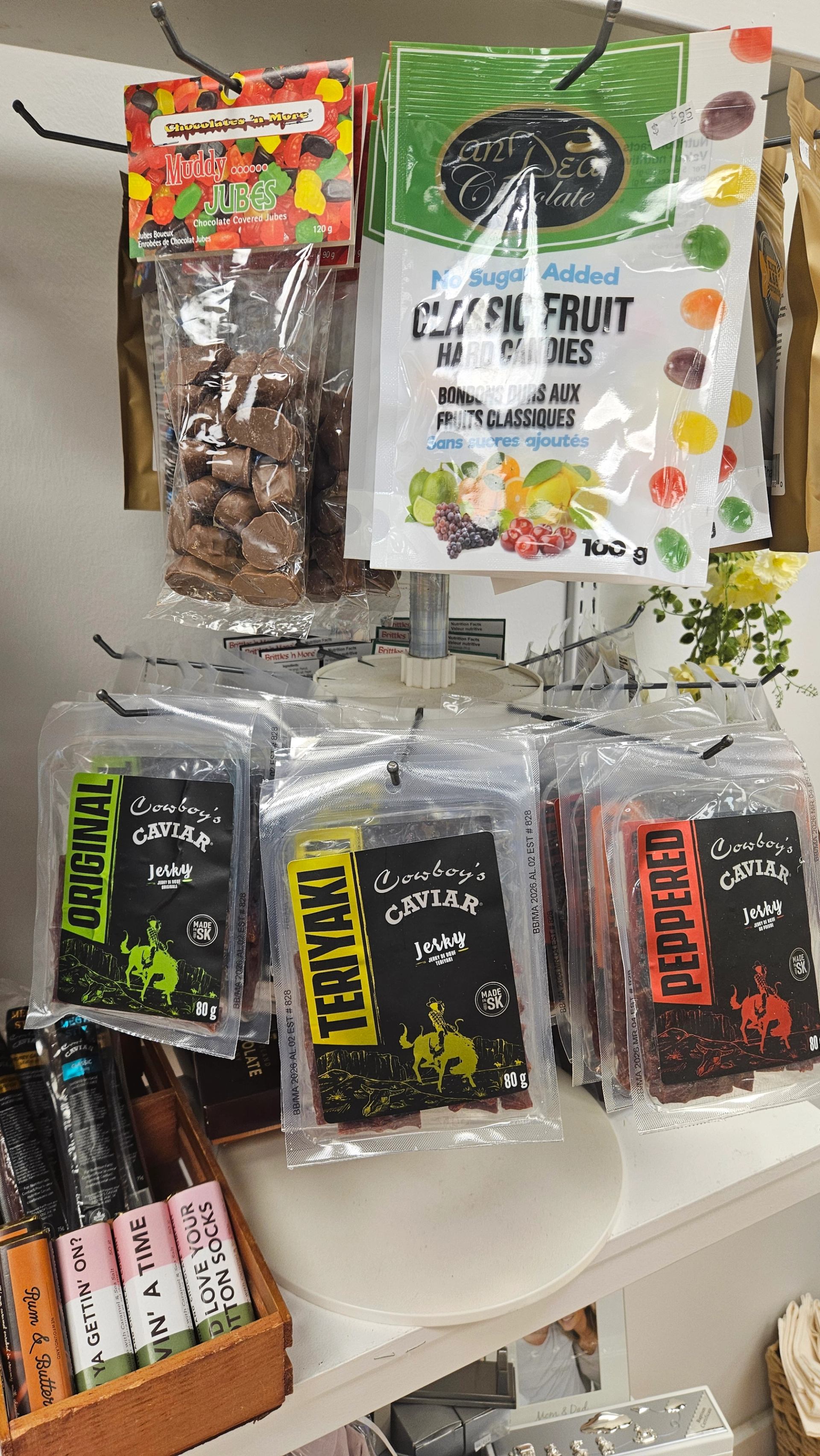 Gummy candies and Carolina Reaper beef jerky hanging on a display rack.