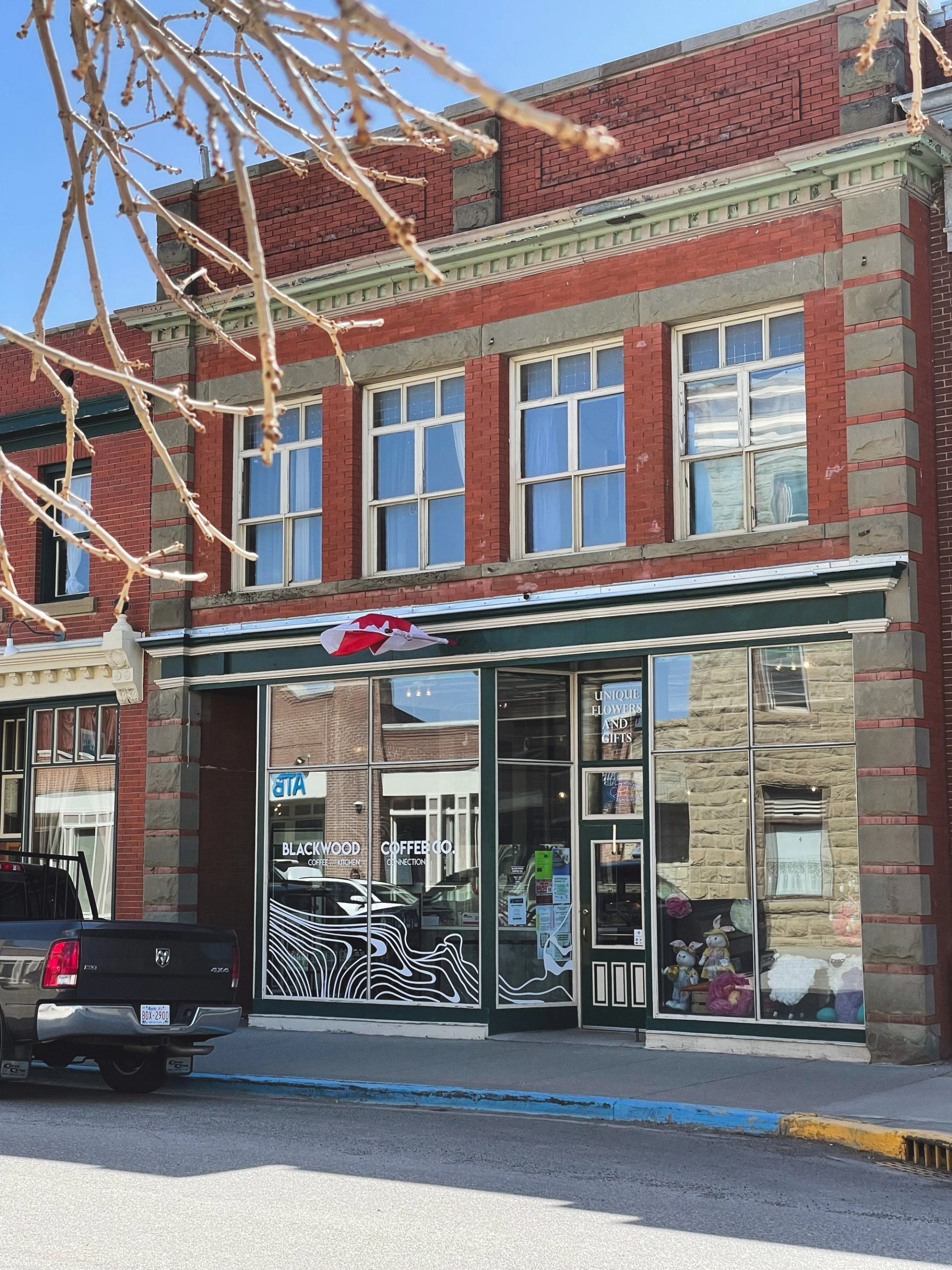 Brick storefront with Blackwood Coffee Co. signage, Canadian flag, and sidewalk display.