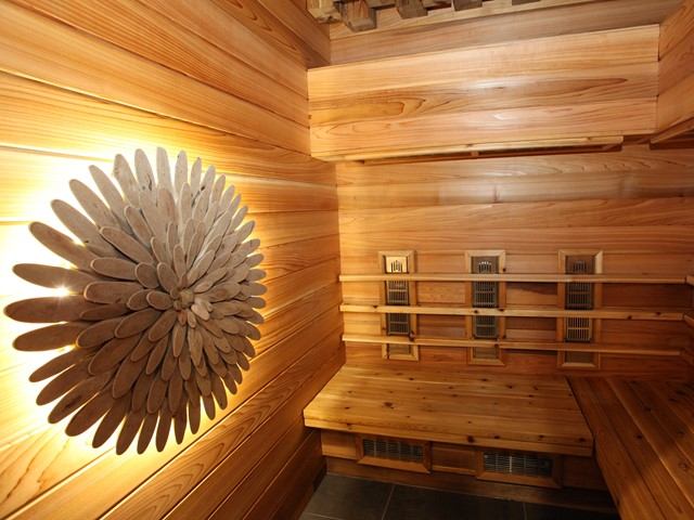 Wood-paneled sauna with bench seating, wall decorations, and a warm, soothing ambiance.