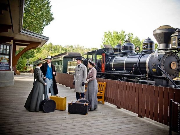 Historical actors in front of the Steam Train at Fort Edmonton Park.