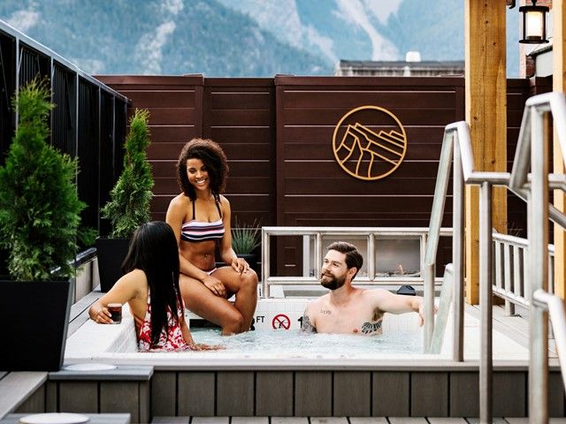 People enjoying the outdoor pool at the Mount Royal Hotel in Banff.