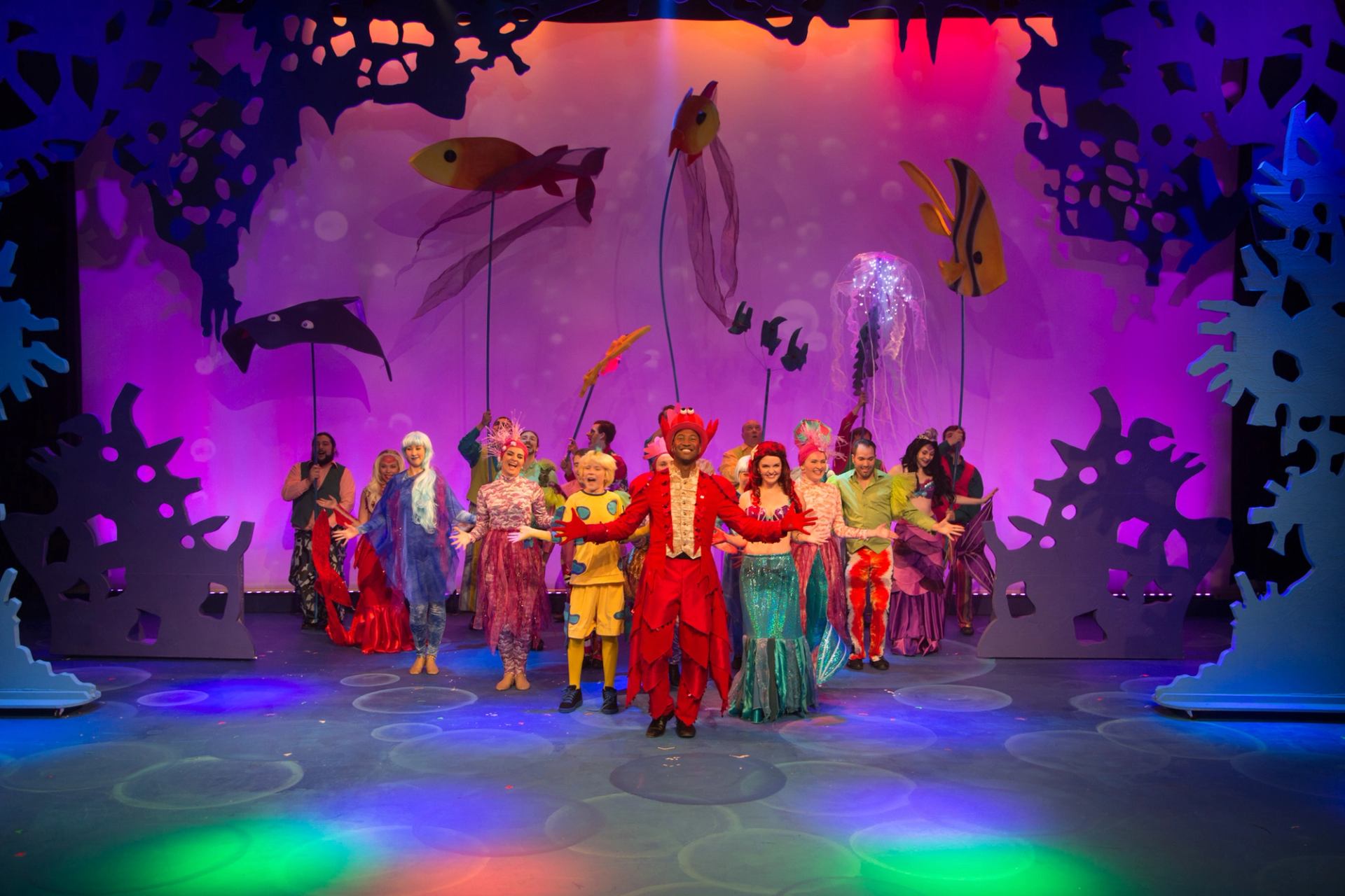 Colorful underwater-themed play at Storybook Theatre with vibrant costumes and set.