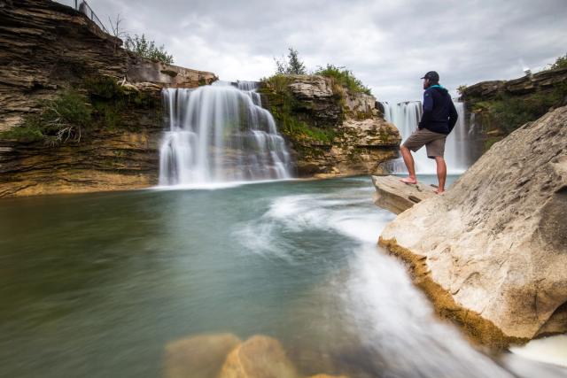 Man enjoying view of the waterfall at Lundbreck Falls.